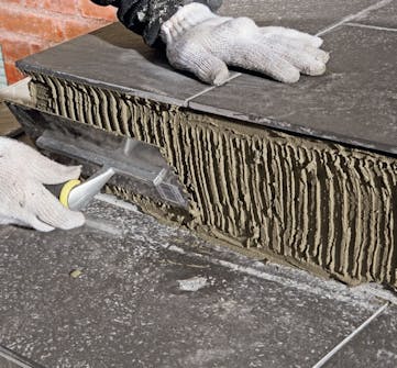 Fliser inngangsparti ute: Smør flislim på opptrinnene Fliser inngangsparti ute: Smør flislim på opptrinnene